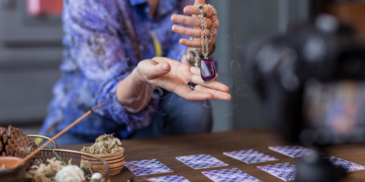 A psychic holds a pendulum