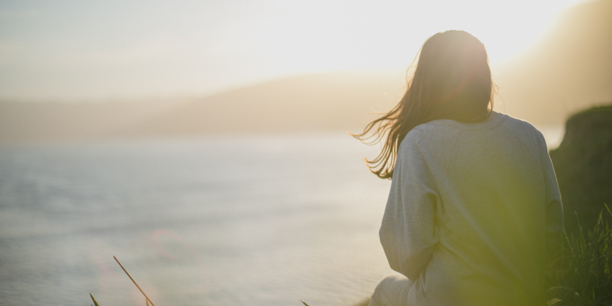 A woman overlooks the ocean.