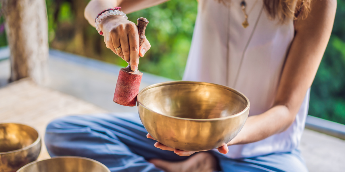 Someone uses a Tibetan singing bowl to create a positive sound vibration.