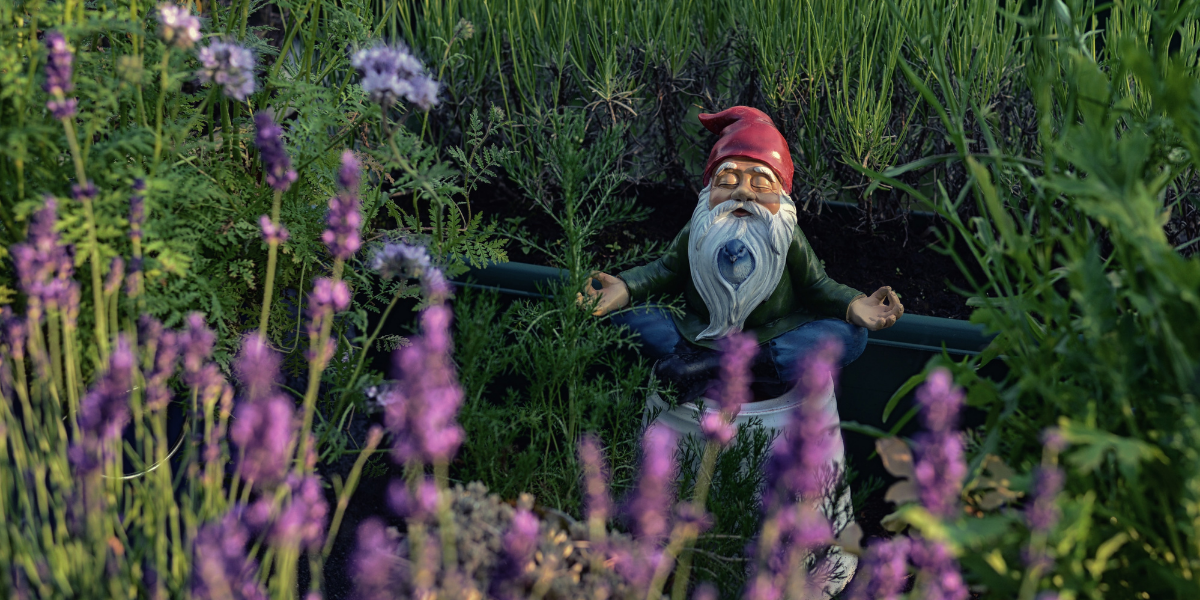 A gnome meditating in a garden.