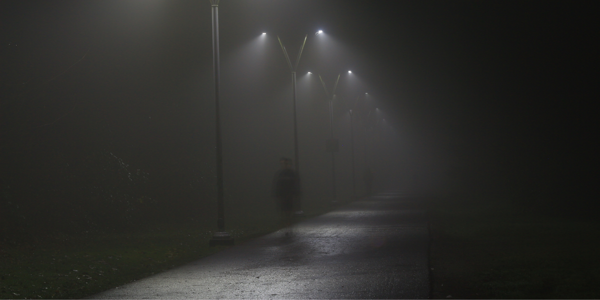A ghostly apparition appears on a dark pathway.